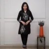 Based on the image provided, this is a black cotton kurta set featuring white floral embroidery. It is commonly sold as a two-piece "co-ord set" that includes a straight-cut kurti and matching pants. Product DetailsFabric: Typically crafted from soft cotton or cotton slub fabric. Design: The set is characterized by intricate white thread embroidery in floral motifs, often positioned on the chest, sleeves, and lower portions of the garment. Style: It usually features a V-neck or round neck design and three-quarter sleeves. 