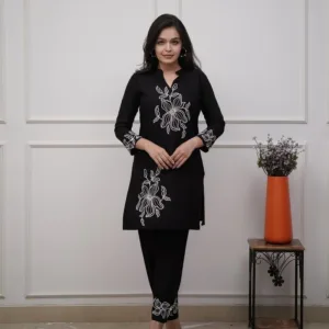 Based on the image provided, this is a black cotton kurta set featuring white floral embroidery. It is commonly sold as a two-piece "co-ord set" that includes a straight-cut kurti and matching pants. Product DetailsFabric: Typically crafted from soft cotton or cotton slub fabric. Design: The set is characterized by intricate white thread embroidery in floral motifs, often positioned on the chest, sleeves, and lower portions of the garment. Style: It usually features a V-neck or round neck design and three-quarter sleeves. 