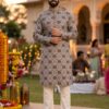 The person in the image is wearing a printed cotton kurta featuring an intricate geometric motif, which is a staple of contemporary Indian festive wear. This specific style, often characterized by its mandarin collar and knee-length straight-cut silhouette, is designed for both comfort and a refined traditional appearance.  Kurta Details & Availability Similar printed kurtas are available from several retailers, typically sold as a set with white trousers (pajamas).  Ethnicity Soft Cotton Kurta Pajama : A close match in style and material, often featuring traditional prints on soft cotton. Sojanya Printed Kurta Sets : Known for offering premium cotton and linen blends with diverse ethnic motifs. : Offers similar multicolor geometric patterns specifically designed for traditional festive occasions. Styling Tips Bottoms: This kurta is traditionally paired with white churidar or straight-cut pajamas to keep the focus on the detailed print.Footwear: Completing the look with dark leather mojaris or loafers, as seen in the image, adds a touch of formal elegance