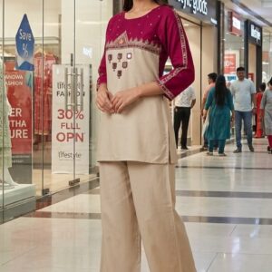 This elegant ethnic outfit features a magenta and beige straight kurta set styled with casual wide-leg trousers and beautifully embroidered footwear, perfect for festive gatherings, semi-formal occasions, or smart casual wear. Kurta & Palazzo Set The focal piece is a two-tone straight-cut tunic paired with loose-fitting trousers. It features a rich magenta color block at the yoke and sleeves offset by a clean, neutral beige lower bodice. The yoke is decorated with geometric patterns, delicate mirror-work elements, and traditional thread embroidery. Get the look: You can discover exact or highly similar versions from brands like or browse the curated collections on major platforms like SDMONILE. Beige Wide-Leg Trousers The top is complemented by relaxed-fit, beige straight parallel trousers that provide a comfortable silhouette while maintaining a polished appearance. Get the look: For standalone options, check out high-quality neutral parallels on  Embroidered Jutti Flats The ensemble is rounded out with dark brown zardozi embroidered juttis that tie the look together with traditional craftsmanship. They feature intricate gold thread detailing on genuine leather.